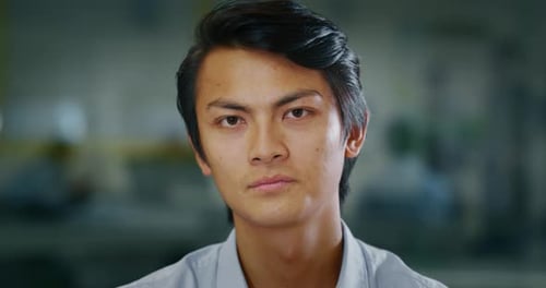 Portrait of an young successful asian businessman is smiling satisfied with his work in camera in