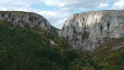 Aerial shot of a drone over mountains in Romania on a sunny day