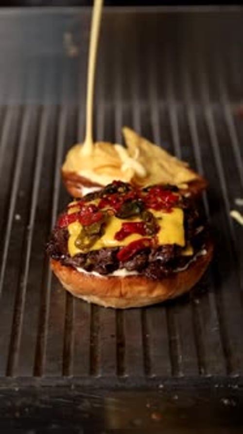 Delicious Cheeseburger Assembled on Metal Grill