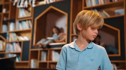 Boy Reads Book in Library, Surrounded by Bookshelves