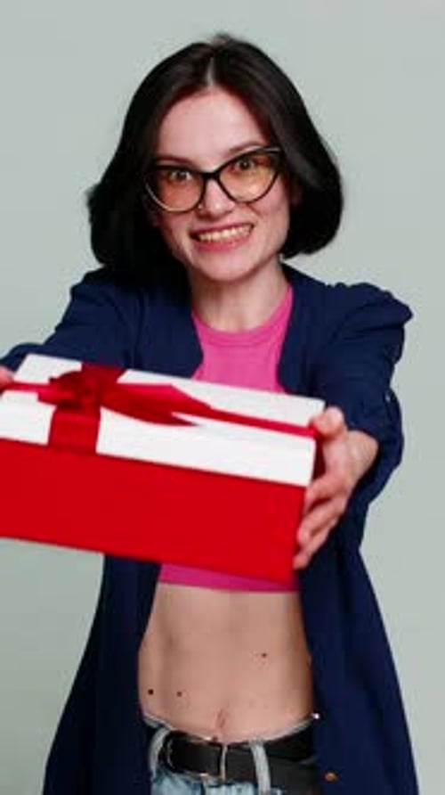 Mulher feliz e animada estendendo as mãos para frente segurando a caixa de presente de aniversário expressando um presente surpresa