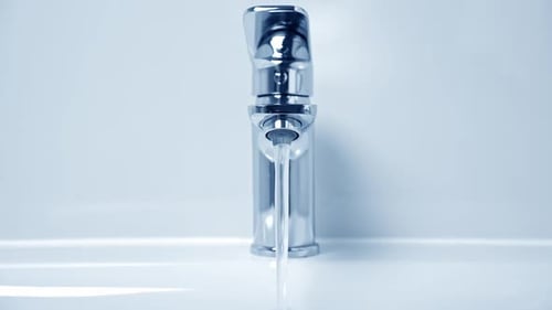 Aus dem Wasserhahn laufendes Wasser, Nahaufnahme, Blauton