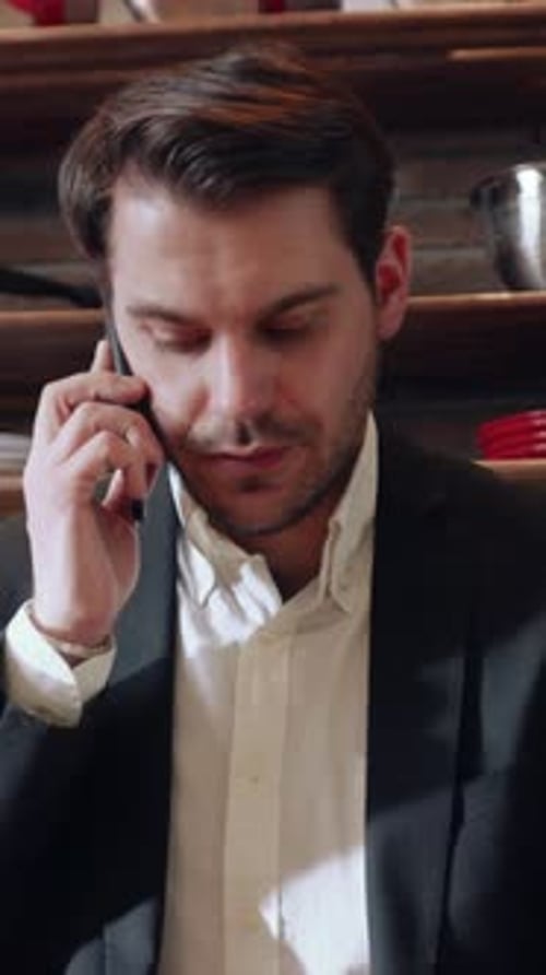 A Businessman Talks on the Phone in a Modern Office Emphasizing Communication and Teamwork