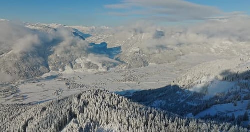 Blick aus der Vogelperspektive auf verschneite Berge und Täler