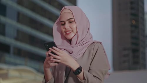 A young Muslim Businesswoman is using smart phone in modern City