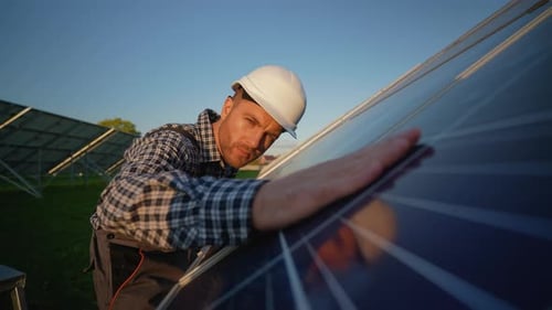Worker Inspects Solar Panel After Installation