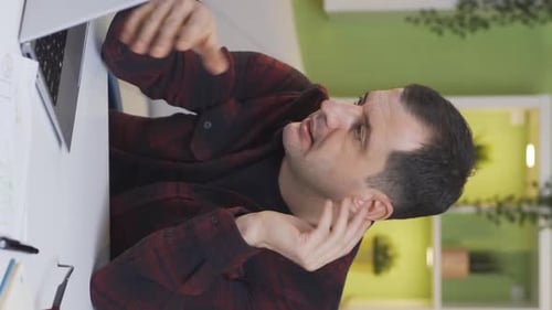 Vertical Video of Mature man working in home office going bankrupt, experiencing burnout.