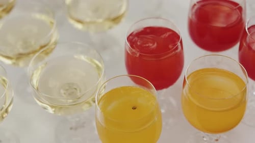 Colorful beverages in glasses on white surface