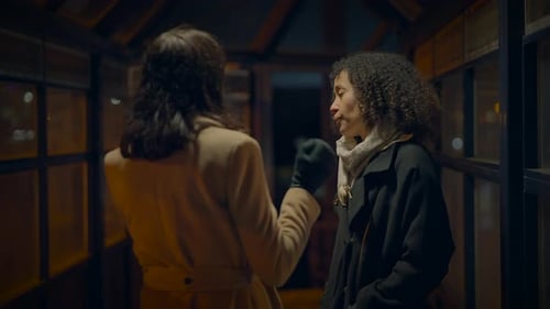 Two Women Talking at Night in City Setting