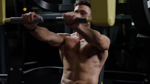 Motivation Athletic Man in the Gym Lifting Blocks on Gym Machine Training on Block Device Slow