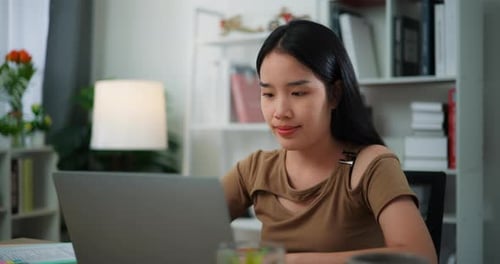 Young Woman Uses Laptop in Home Office