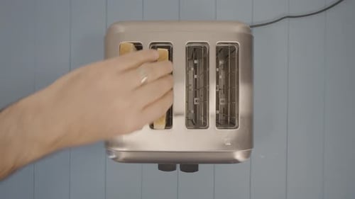 top down view of three Toasted Slices of Sandwich Bread put inside a Chromed Toaster