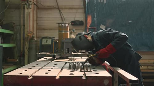 Welder Using Welding Torch in Industrial Workshop
