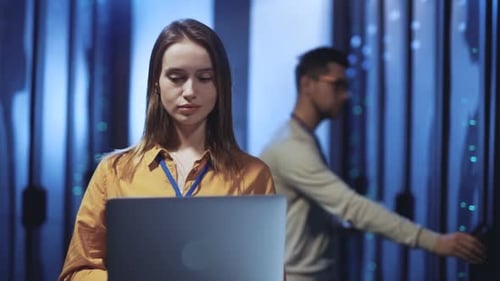 Woman Works on Laptop in Data Center