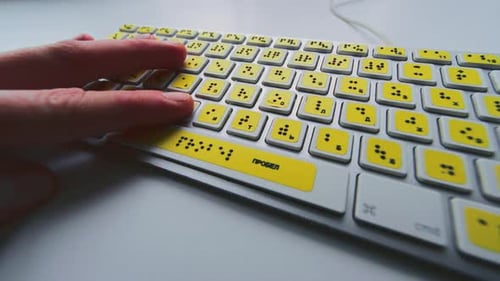 Computertastatur mit Braille-Schrift, Alphabet, blinde Person tippt Wörter, Hände