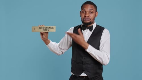 Hotel Concierge Using a Wall Indicator to Guide Clients to the Conference Room