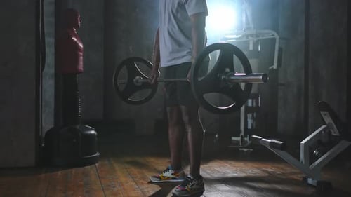 Muscular Man Deadlifting Barbell in Gym