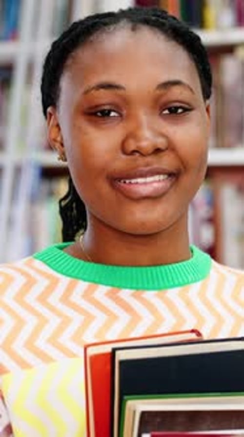 Portrait of African American Female Student with Books in the Library