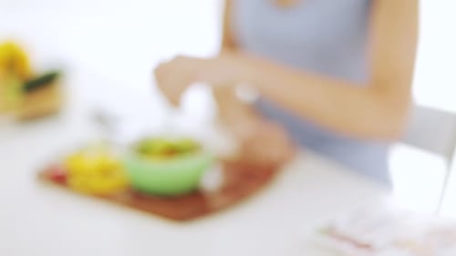 Woman Eats Colorful Salad at Table Indoors