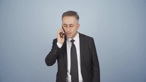 Businessman Talking on Cellphone in Suit, Studio Shot