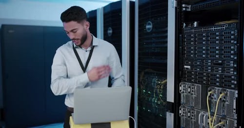 Man Works With Laptop in Data Center