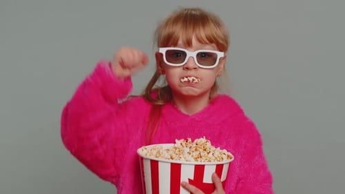 Young Child Enjoys Popcorn Wearing 3D Glasses