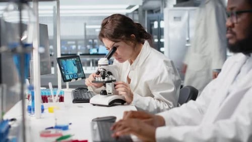 Scientists Working with Microscope and Tablet in Lab
