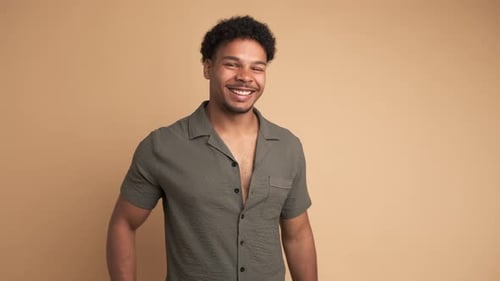 Cheerful Man Looking at Camera in Beige Studio