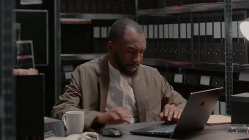 Focused Man Working on Laptop in Office