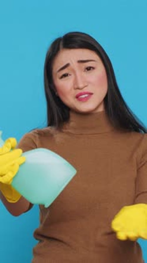 Vertical Video Upset House Cleaner Wearing Yellow Rubber Gloves While Showing Chemical Detergent