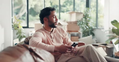 Man Relaxing on Couch Using Mobile Phone Indoors