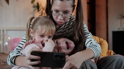 Three Children Posing with Phone on Birthday