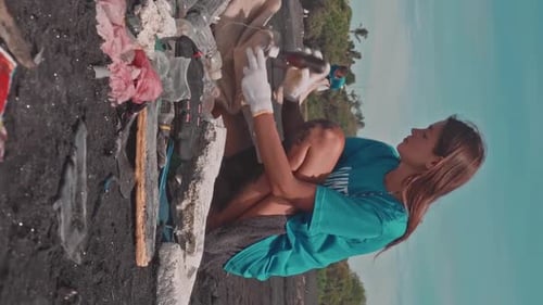 Young Positive Caucasian Woman with Smile Helps Remove Trash From Beach