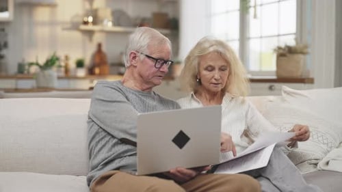 Mature Couple Working on Finances with Laptop at Home
