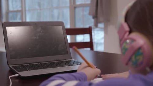 Female student distance learning with a blank laptop screen.