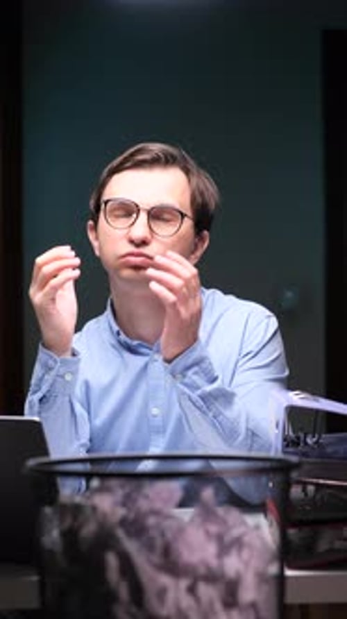 Vertical Video Man in Office Throws Paper in Trash Bin Out of Boredom and Gets Upset After Prank