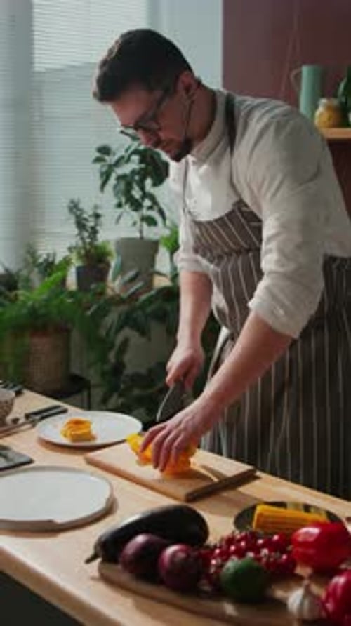 Chef Cutting Yellow Bell Pepper in Kitchen