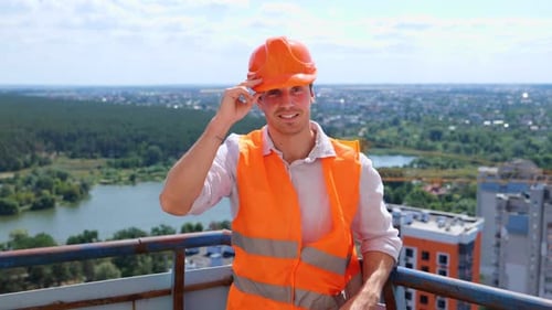 Smiling Man in Hardhat Stands on Rooftop