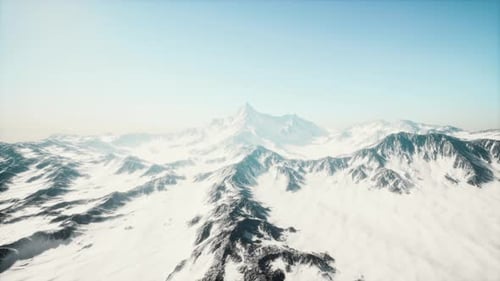 Aerial View of Majestic Snow-Capped Mountains Under Clear Sky