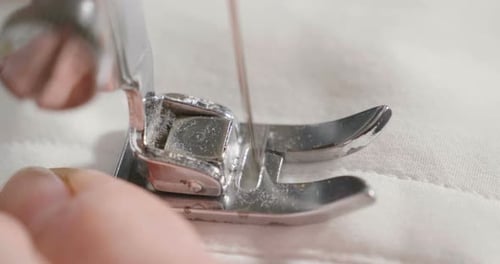 Close Up of Sewing Machine Sewing White Fabric