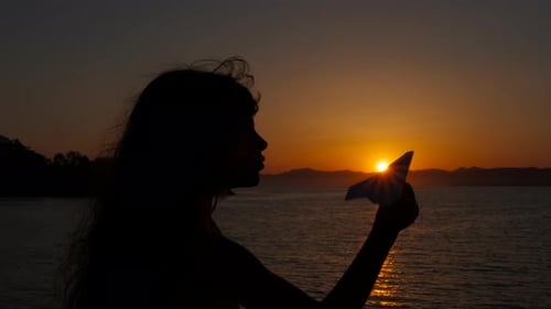 Child with Paper Plane By Evening Sea