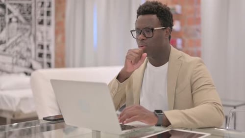 Adult Using Laptop at Desk Coughing