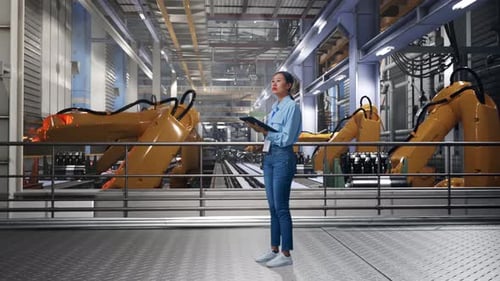 Woman Inspecting Automated Factory with Tablet