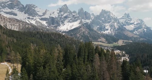 Snowy Rugged Mountains Of The Dolomites With Coniferous Forest In Foreground. Italian Alps. tilt-up
