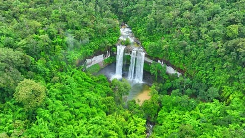 Picturesque Waterfall Flowing Through Lush Green Forest