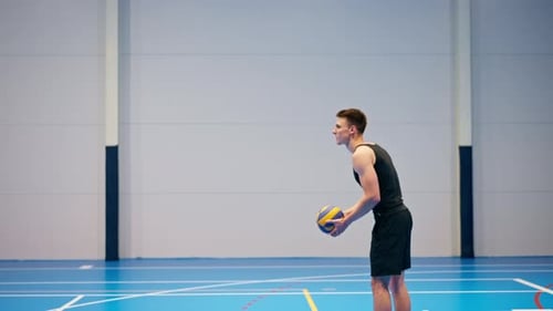 Male Athlete Serving Volleyball in Indoor Gymnasium