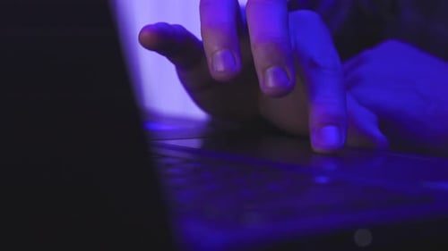 Mains d'homme tapant sur le clavier d'un ordinateur portable la nuit Concept de travail en ligne