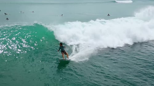 High Above View Showcasing Surfer Balancing On Crest Of Vibrant Blue Wave