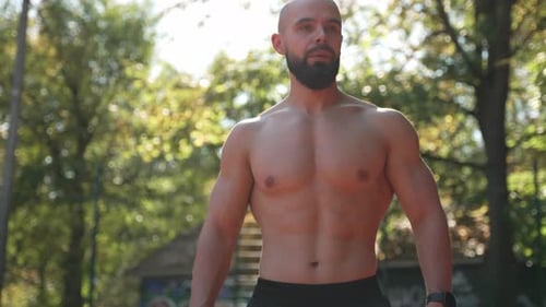 Muscular Man Walking Shirtless Outdoors on Sunny Day