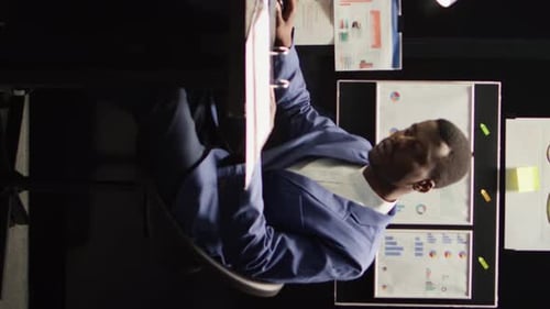 Businessman Reviews Financial Documents in Office, Vertical Video
